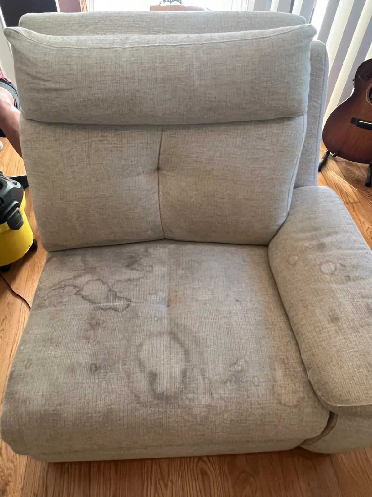 Módulo de sofá claro com braço à direita, com grandes auréolas no assento, antes da limpeza