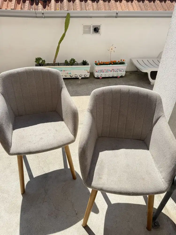 Duas cadeiras de tecido claro depois da limpeza, num terraço à luz do dia