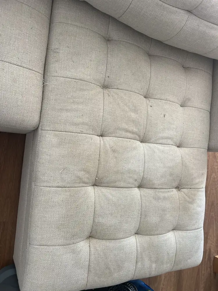 Chaise longue de sofá de canto bege capitonê com manchas escuras antes da limpeza